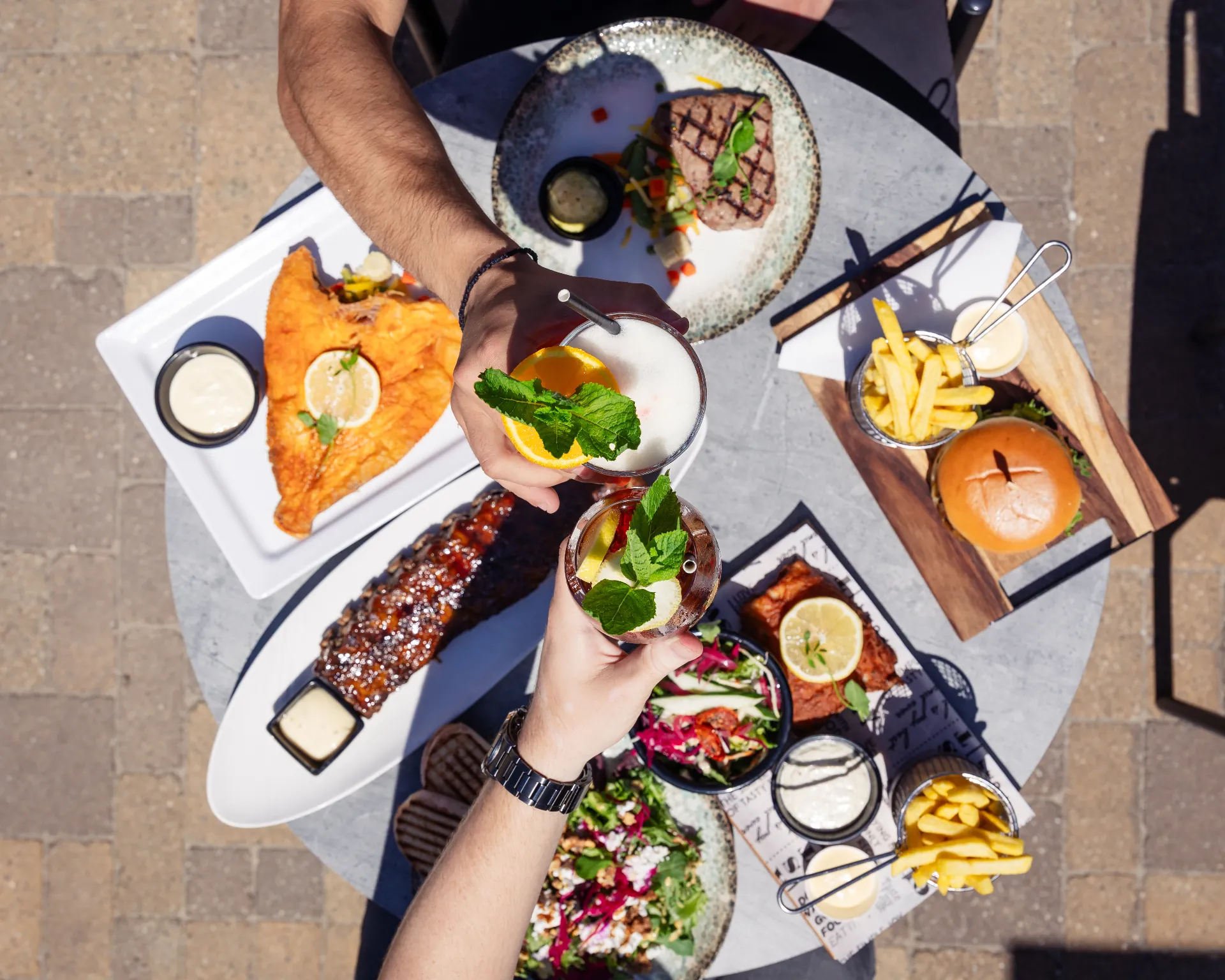Proosten aan tafel met spare ribs, schol, burger en salade